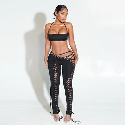 Woman wearing a black strappy outfit on a white background